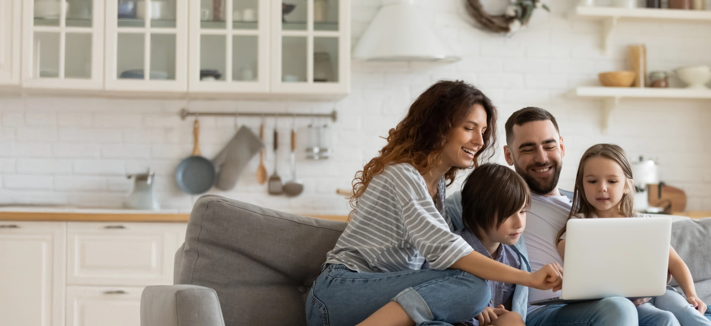 glueckliche familie sitzt am laptop